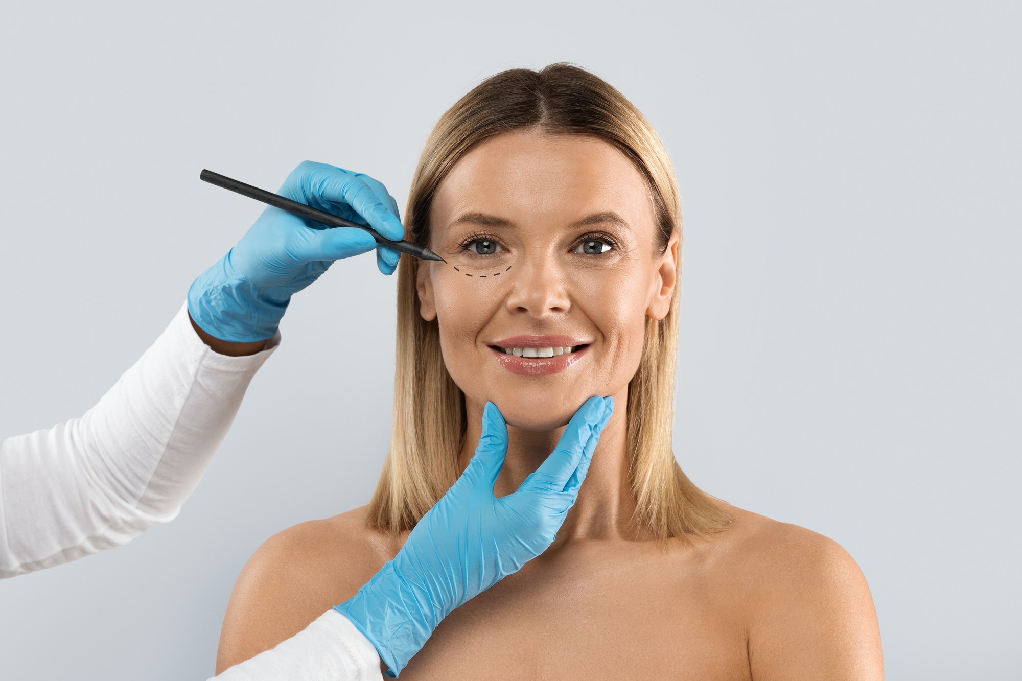 surgeon-drawing-perforation-lines-on-woman-face-for-plastic-surgery.jpg